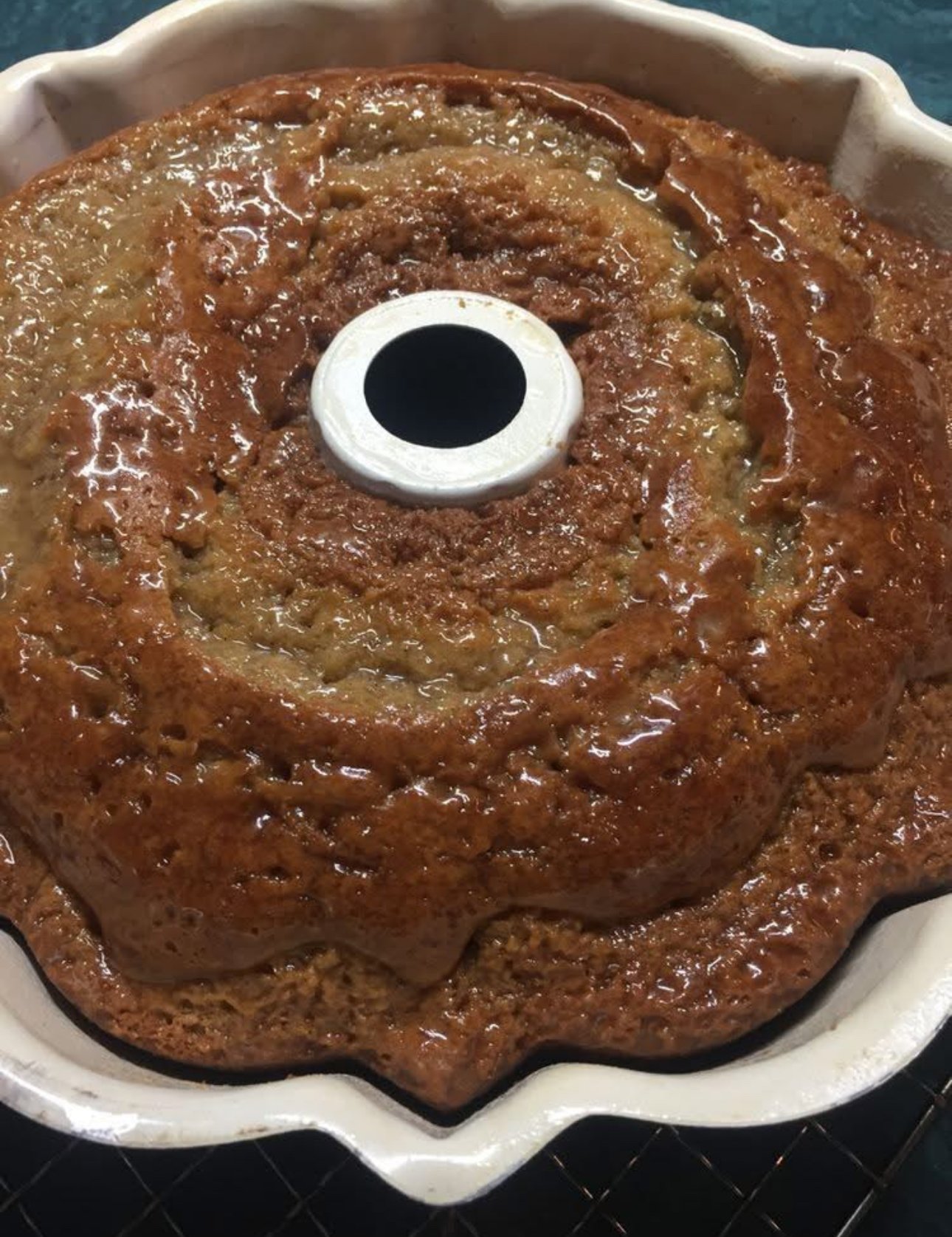 A golden brown Crack Cake baked in a bundt pan with buttery glaze poured over the top