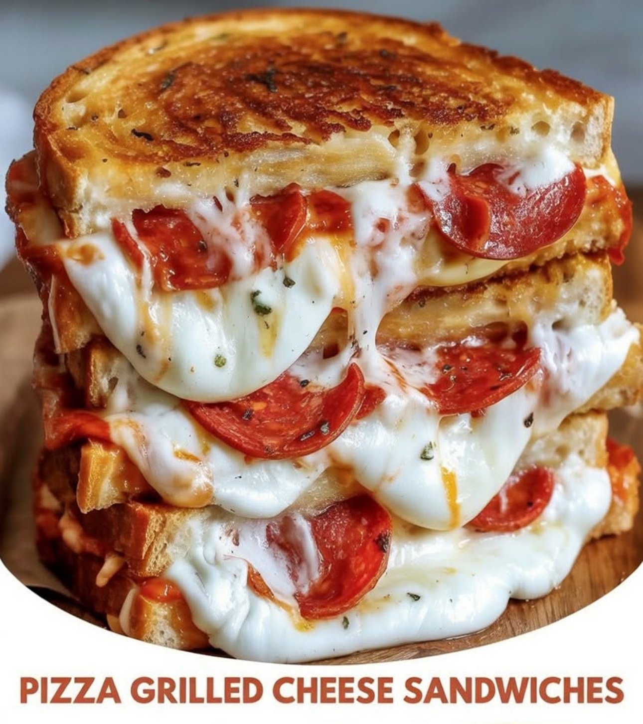Golden-brown pizza grilled cheese sandwich with melted mozzarella, pepperoni, and a side of marinara sauce for dipping.