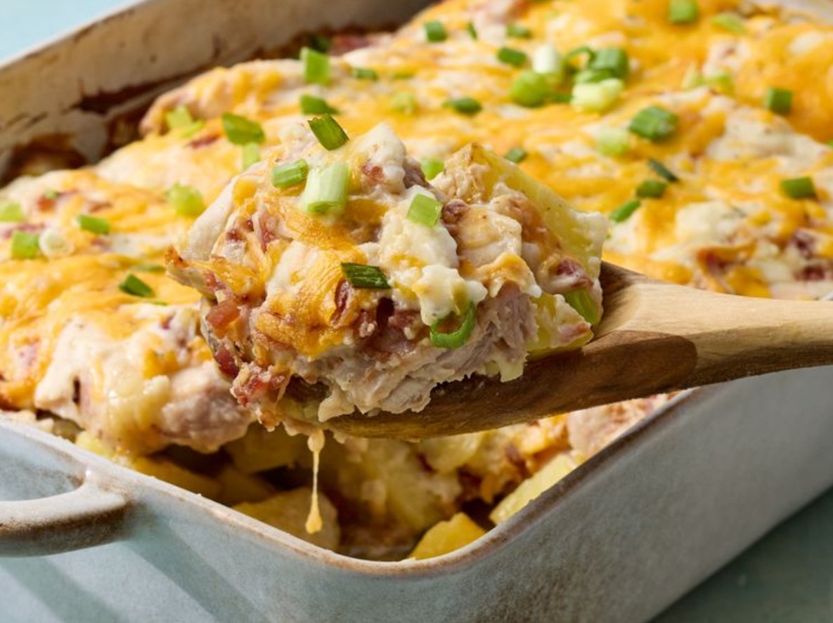 Golden potato bake with tender chicken, crispy bacon, melted cheddar cheese, and ranch seasoning, baked in a casserole dish.