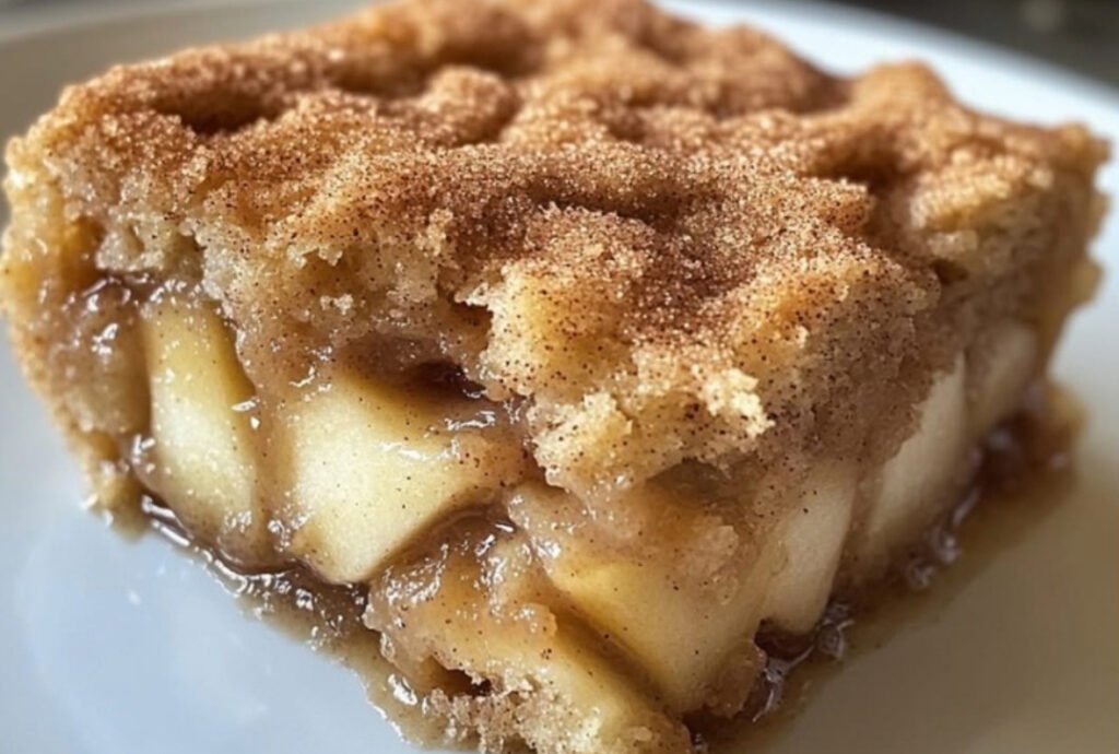 Warm Apple Snickerdoodle Dump Cake with golden cinnamon cookie topping and scoop of vanilla ice cream