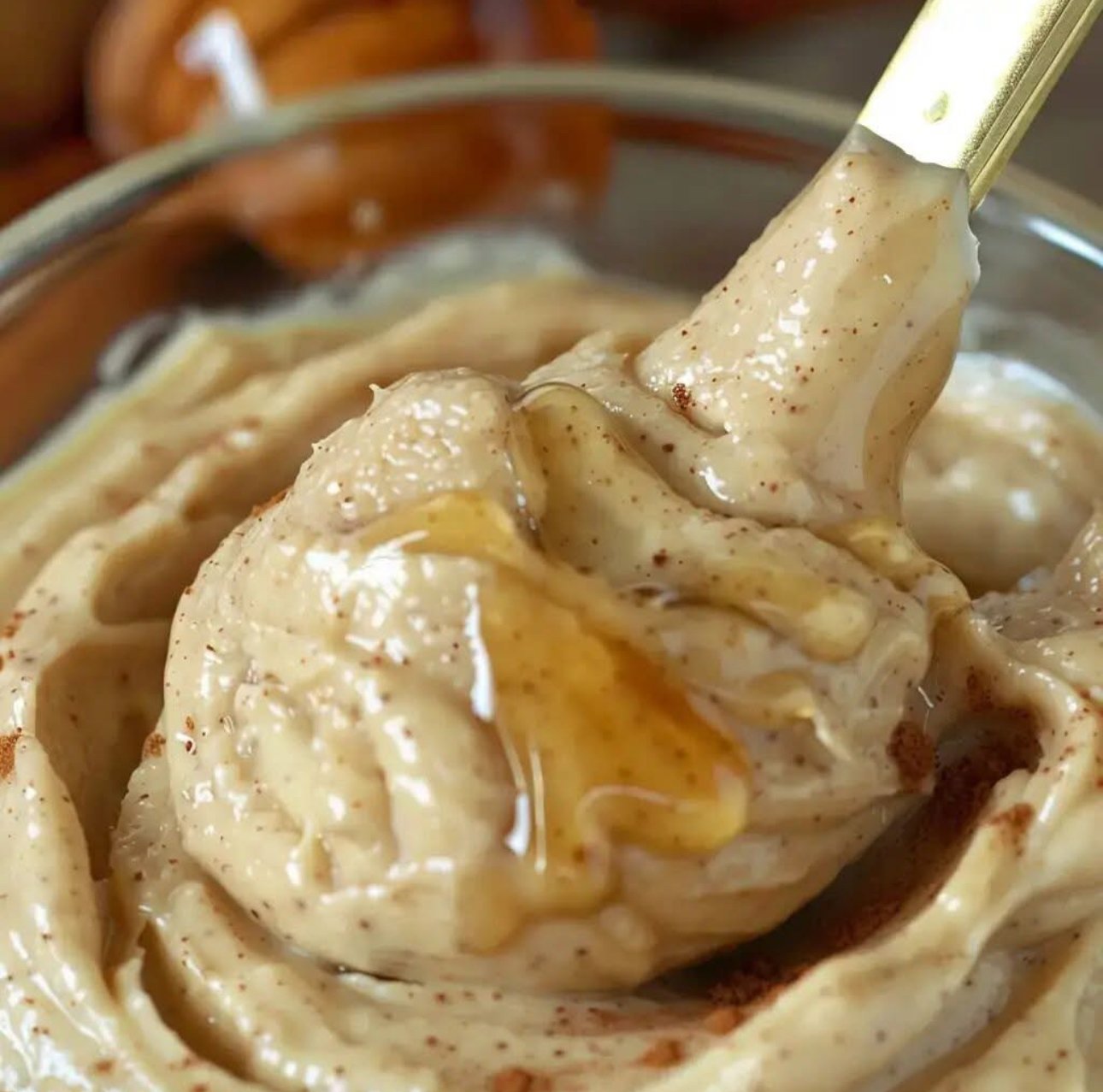 A creamy bowl of homemade Texas Roadhouse cinnamon honey butter with honey drizzle and cinnamon sticks.
