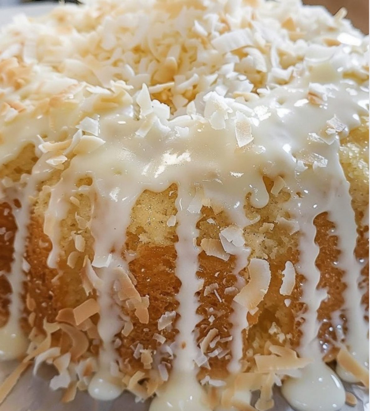 Homemade coconut pound cake with coconut glaze and shredded coconut garnish.
