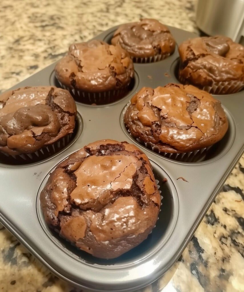 Death by Chocolate Muffins with chocolate chips cooling on a wire rack.