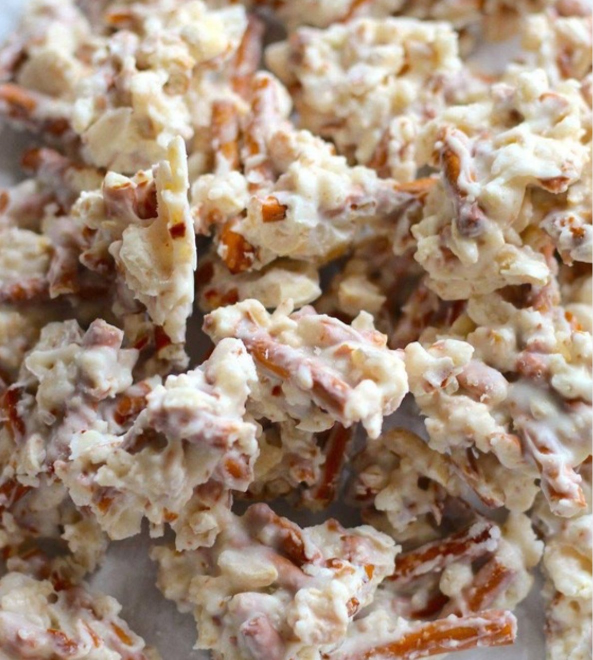 Homemade Ragtag Candies made with chocolate, butterscotch, marshmallows, peanuts, pretzels, and M&M’s on parchment paper.