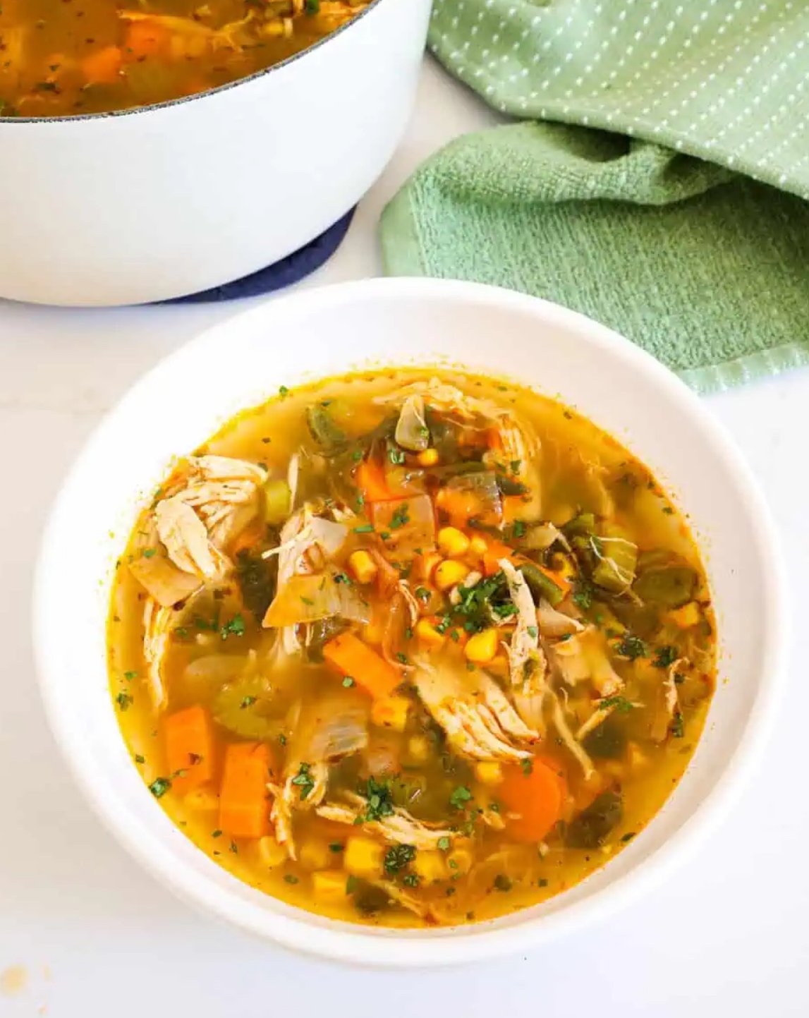 Bowl of chicken poblano soup with roasted poblano peppers, corn, and shredded chicken, garnished with fresh cilantro