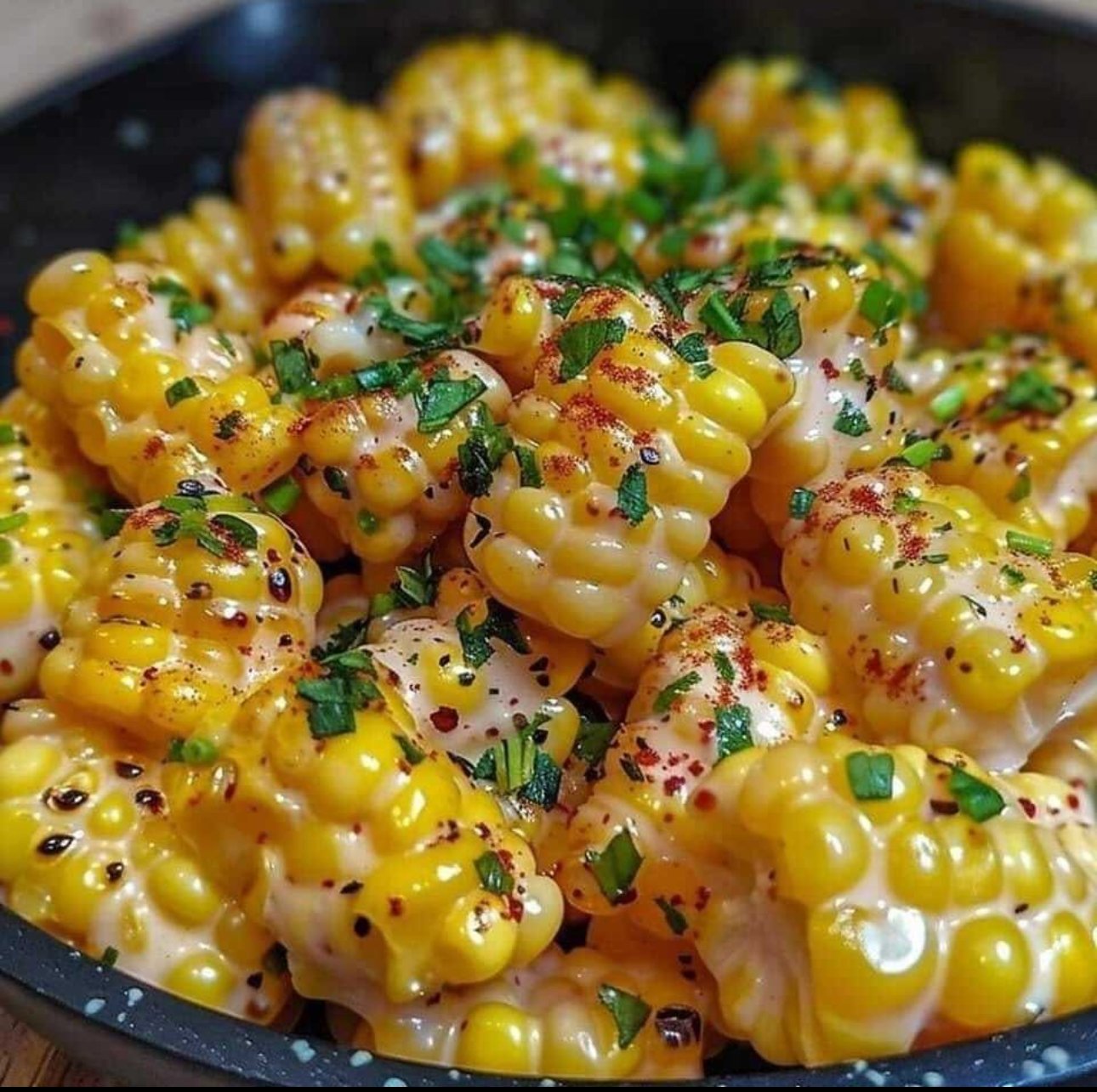 Skillet of honey butter corn with cream cheese, creamy and golden.