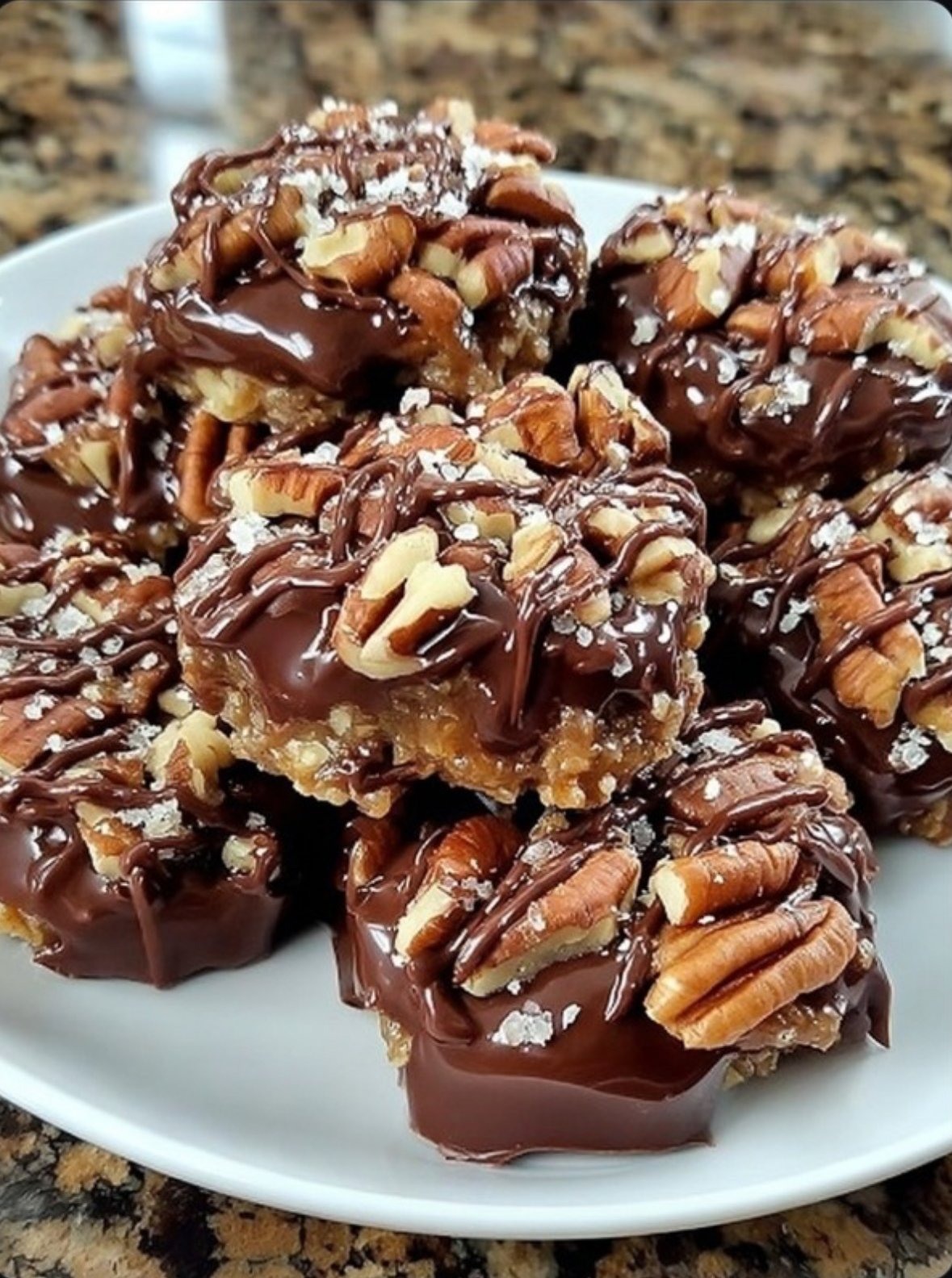Chocolate pecan turtle clusters with caramel and chocolate, on parchment paper.