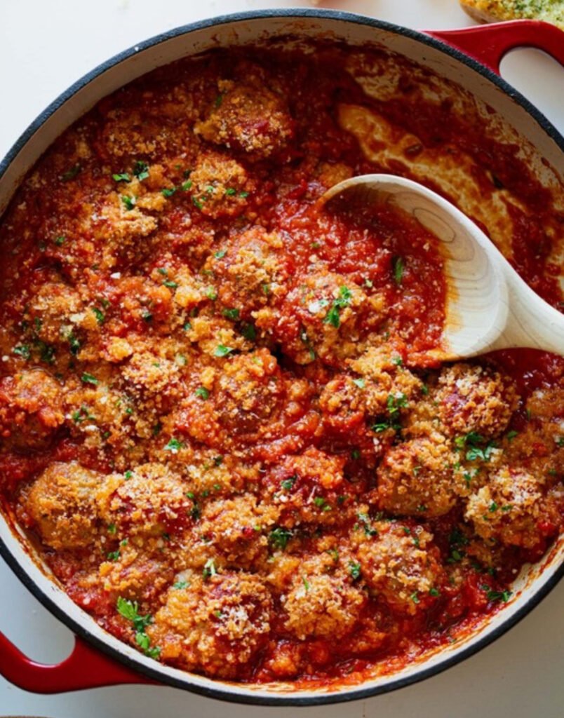 Tender ricotta meatballs baked in marinara sauce with crispy Parmesan panko topping